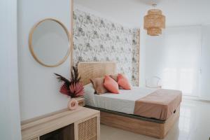a bedroom with a bed with a mirror and a table at Meu Lar in Rianjo