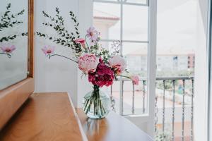 a vase filled with pink flowers sitting on a table at Meu Lar in Rianjo +14 photos