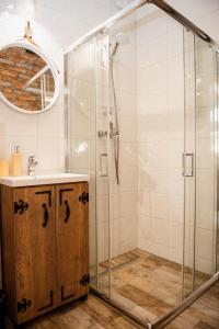 uma casa de banho com um chuveiro e um lavatório. em Bez Zegarka Osada nad Jeziorem Rospuda em Filipów