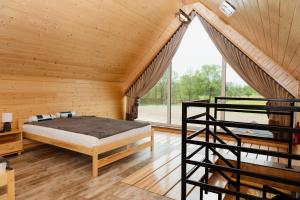 ein Schlafzimmer mit einem Bett und einem großen Fenster in der Unterkunft Bez Zegarka Osada nad Jeziorem Rospuda in Filipów
