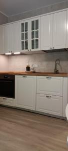 a kitchen with white cabinets and a sink at Casa Natura in Castione della Presolana