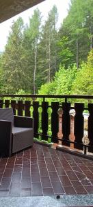 a balcony with a bench and a fence with trees at Casa Natura in Castione della Presolana