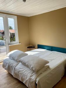 een slaapkamer met een groot bed met een blauw hoofdeinde bij Pas Ireną Šventojoje in Palanga