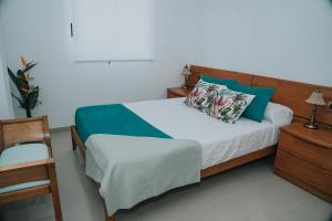 a bedroom with a bed and a chair at Meu Lar in Rianjo