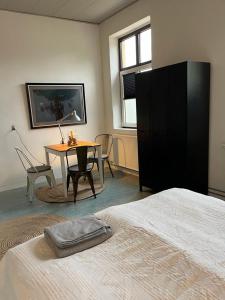 Habitación con 1 dormitorio con mesa y 1 cama en Room 7 - Hawkraft kulturhotel, en Vestervig