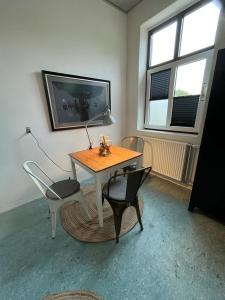 een kamer met een tafel en stoelen en een televisie bij Room 7 - Hawkraft kulturhotel in Vestervig