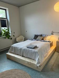 1 cama con marco de madera en un dormitorio en Room 7 - Hawkraft kulturhotel, en Vestervig