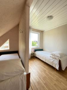 een slaapkamer met twee bedden en een raam bij Pas Ireną Šventojoje in Palanga