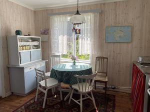 a dining room with a table and chairs and a window at Aabu Maja in Kõrgessaare