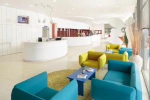 a lobby with blue and yellow chairs and a counter at Apartments Polynesia Plava Laguna in Umag