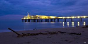 a building on a pier in the water at night at Caravel Appartamentini in Lido di Camaiore