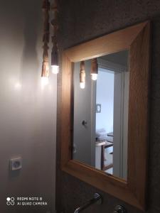 La salle de bains est pourvue d'un miroir avec un cadre en bois et un lavabo. dans l'établissement Chaido Studios, à Plaka Milou