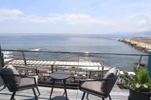 een balkon met stoelen en een tafel en de oceaan bij La casa del pescatore in Cala Gonone