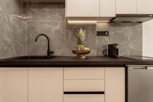 una cocina con fregadero y una piña en una encimera en La Maison Suites, en Zakynthos