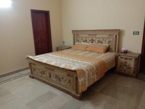 a bedroom with a bed and two night stands at Amira Villa 1 Kanal 5 bedroom house, Johar Town Lahore in Lahore