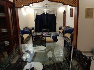 a living room with couches and a glass table at Amira Villa 1 Kanal 5 bedroom house, Johar Town Lahore in Lahore
