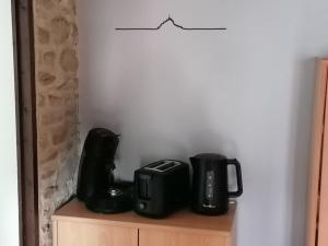 a coffee maker and a toaster sitting on a cabinet at Sunset Family Guesthouse Mont Saint Michel in Céaux