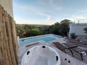 a bath tub sitting next to a swimming pool at Statera Host in Alto Paraíso de Goiás