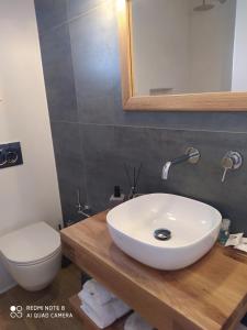 a bathroom with a white sink and a toilet at Chaido Studios in Plaka Milou