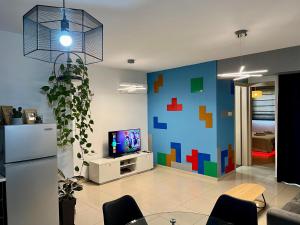 a living room with a pixelated wall and a tv at Fat Cow Apartment 103 in Larnaka