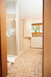 a bathroom with a shower and a tiled floor at Haus Sonnwies in Reit im Winkl