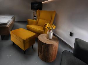 uma sala de espera com uma cadeira amarela e uma mesa em Rooms Svoboda em Olomouc
