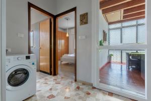 a laundry room with a washing machine and a window at Cà Licio in Fiesso Umbertiano