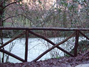 un puente de madera frente a un río en Il casale di Pino e Rita, en Subiaco