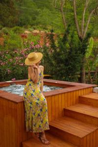 a woman in a dress and hat talking on a cell phone at Dalya Life in Göcek