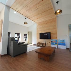 a living room with a couch and a coffee table at Onthestone Pension in Seogwipo