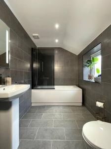 a bathroom with a tub and a toilet and a sink at Modern and spacious house with Hot Tub in Lincolnshire