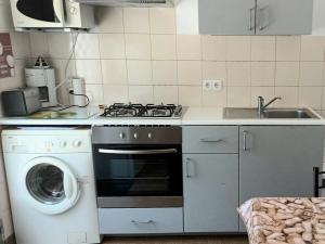 a kitchen with a stove and a washing machine at Casa da Costureira in Olival