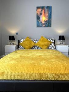 a bedroom with a large yellow bed with two lamps at Modern and spacious house with Hot Tub in Lincolnshire