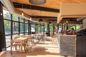 a restaurant with tables and chairs and windows at CityKamp Lyon in Dardilly