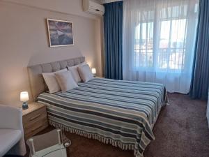 a bedroom with a large bed with a window at Guest house Marina in Obzor
