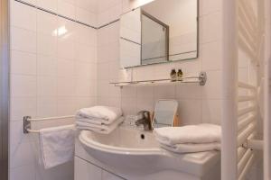 a white bathroom with a sink and a mirror at Le Chat Botté in Saint-Clément-des-Baleines