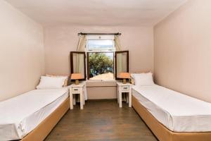 two beds in a room with a window at Club Patara Villas in Kalkan