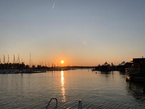 um pôr do sol sobre uma marina com barcos na água em Sonniges 4 **** DG-Apartment mit Aufzug+Seeblick em Ramsberg