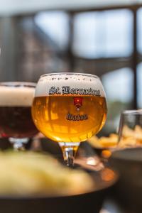 two glasses of beer sitting on a table at Guesthouse de la Paix in Poperinge