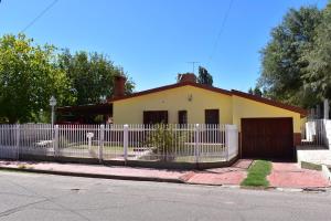 una cerca blanca frente a una casa en Casa Lucía en Villa Unión