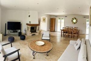 uma sala de estar com um sofá e uma mesa em Belle villa avec jardin piscine et salle de sport em Montauroux