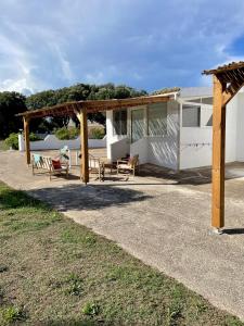 Camping Residence Chalet La Pomposa Terrazzoni في بونيفاسيو: بيت فيه بيرغولا وفناء