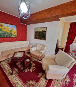 a living room with a couch and chairs and a table at Apartmani M br5 in Topola