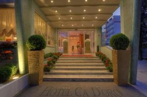 a hotel lobby with stairs and plants and a hotel door at Hotel Ca' D'Oro in Bibione