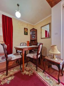 a dining room with a table and chairs and a mirror at Apartmani M br5 in Topola