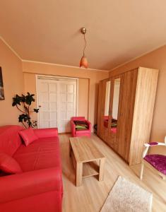 a living room with a red couch and a table at Apartmani M br5 in Topola