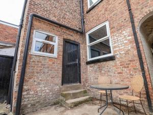 a brick building with a table and two chairs at Oneofour in Chester