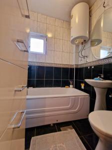 Topola的住宿－Apartmani M br5，带浴缸、盥洗盆和卫生间的浴室