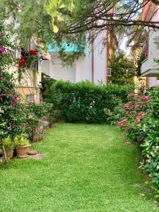 a yard with green grass and flowers in front of a house at Alma Sea House in Hanioti