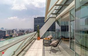 Un balcón con dos sillas y una mesa en un edificio. en Casa Reforma by Kukun, en Ciudad de México 89 fotos más